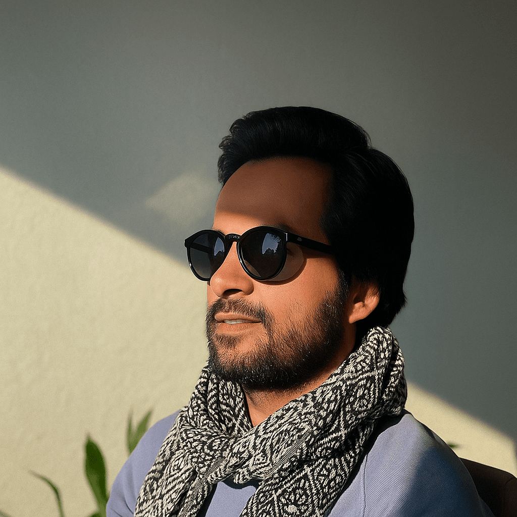 Portrait of A.R. Shafiee wearing sunglasses and a patterned scarf